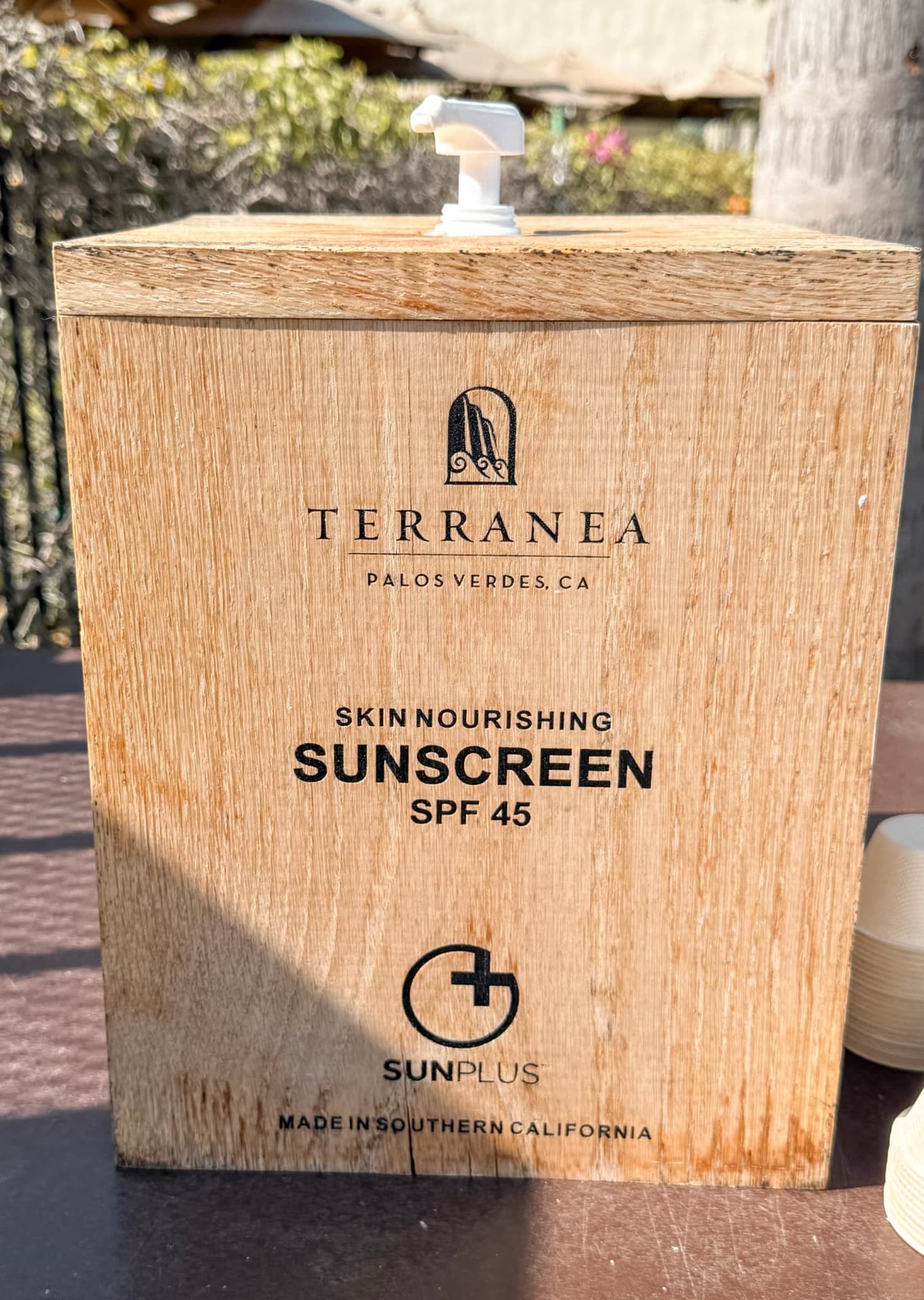 A wooden sunscreen dispenser beside the Resort Pool at Terranea