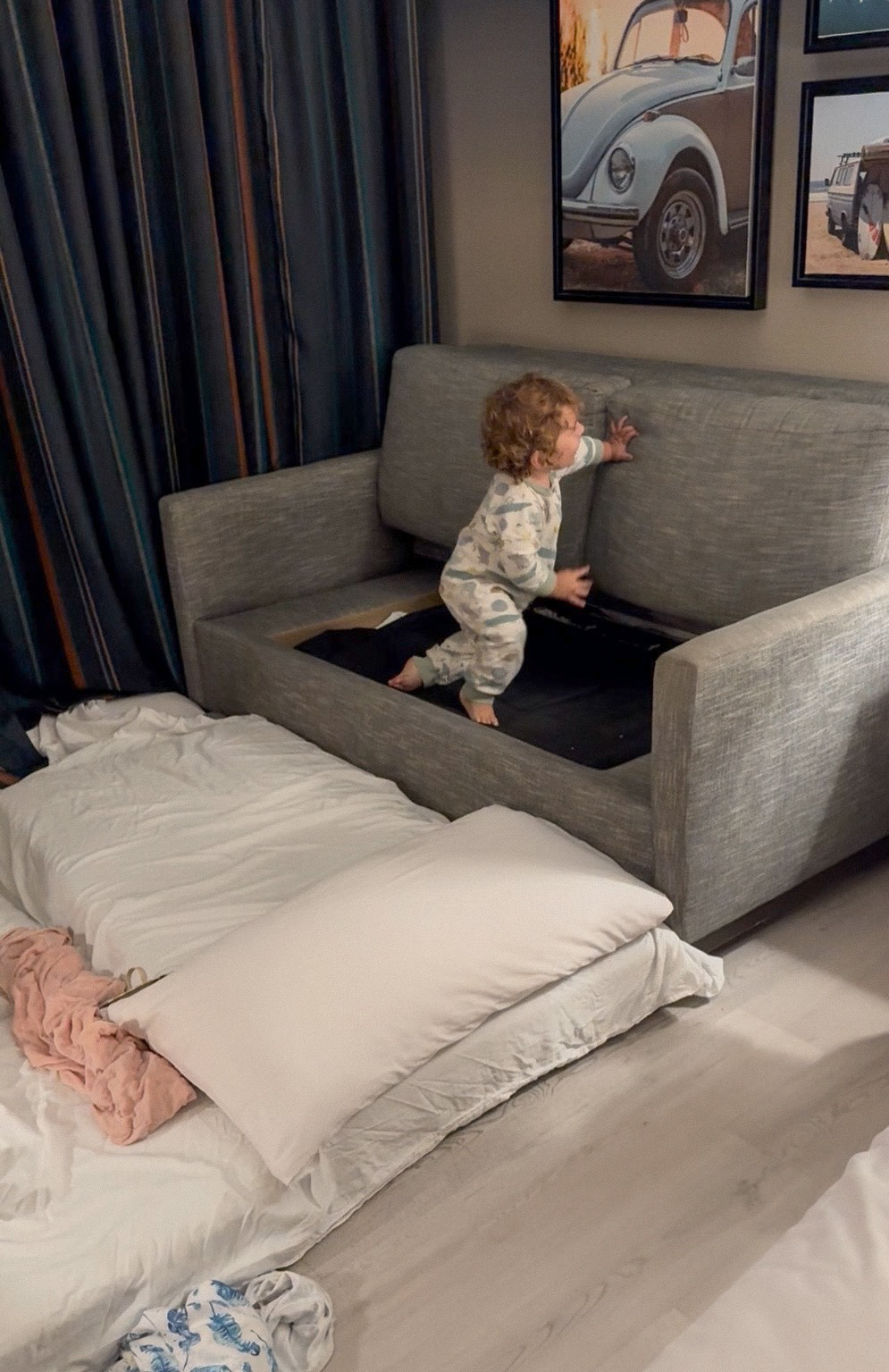 Our floor bed set up beside the couch in our room at Inn at the Pier, with one of our 14-month-old twins climbing on the couch