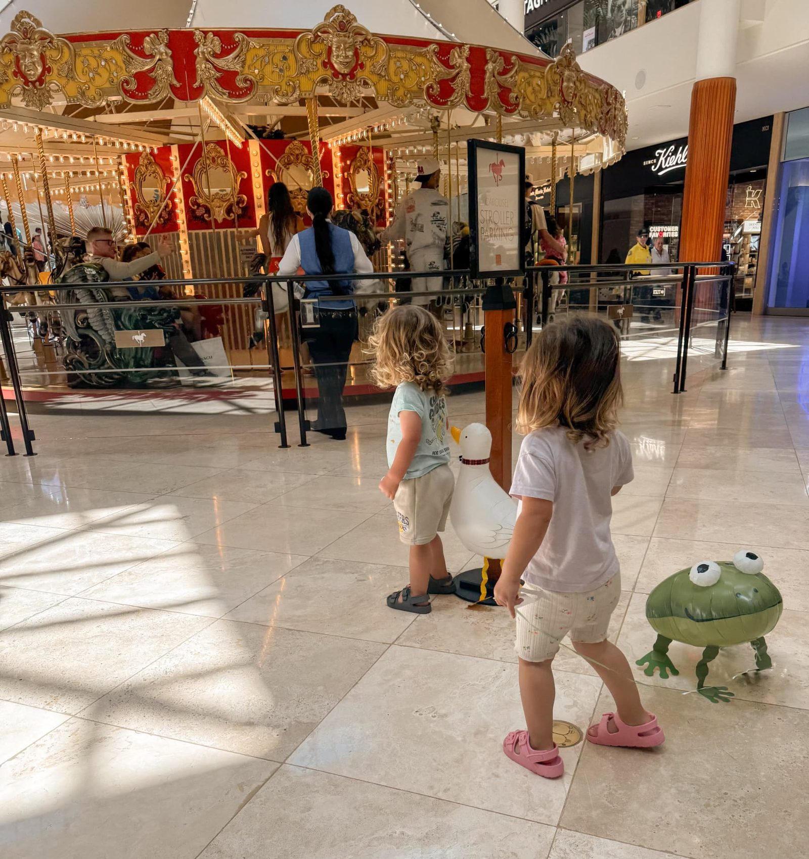 Two-year-old twins watching the carousel at South Coast Plaza during a stay at The Westin South Coast Plaza