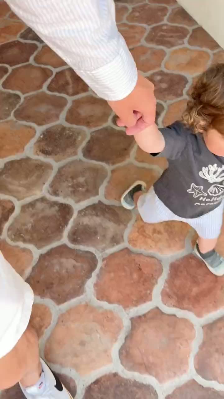 A short clip walking hand in hand with a toddler along the terracotta-tiled path near the Apothecary at Ojai Valley Inn, on the way back to the room