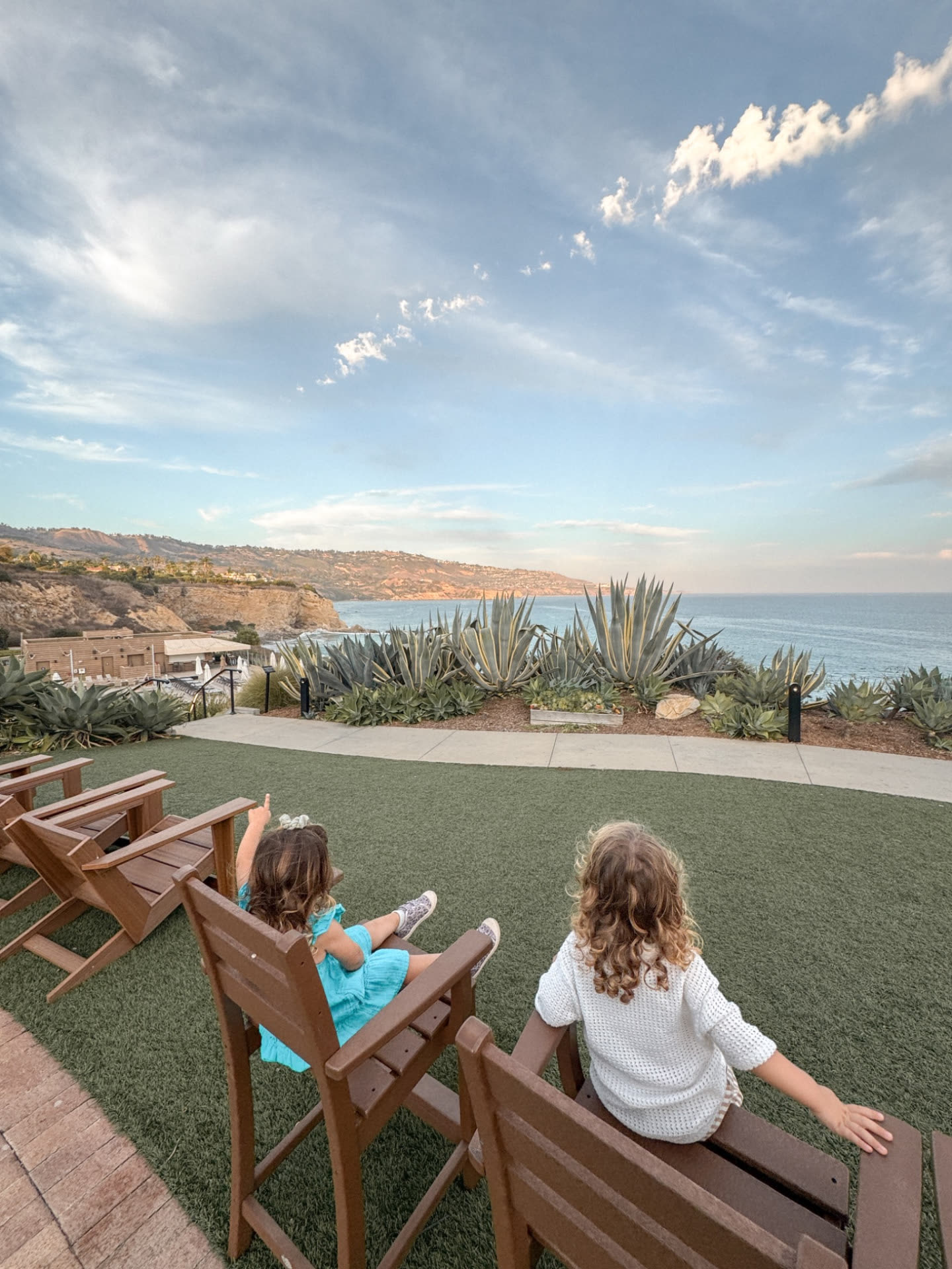 Our two-year-old twins sitting in Adirondack chairs on the bluff at Terranea, looking out over the Pacific
