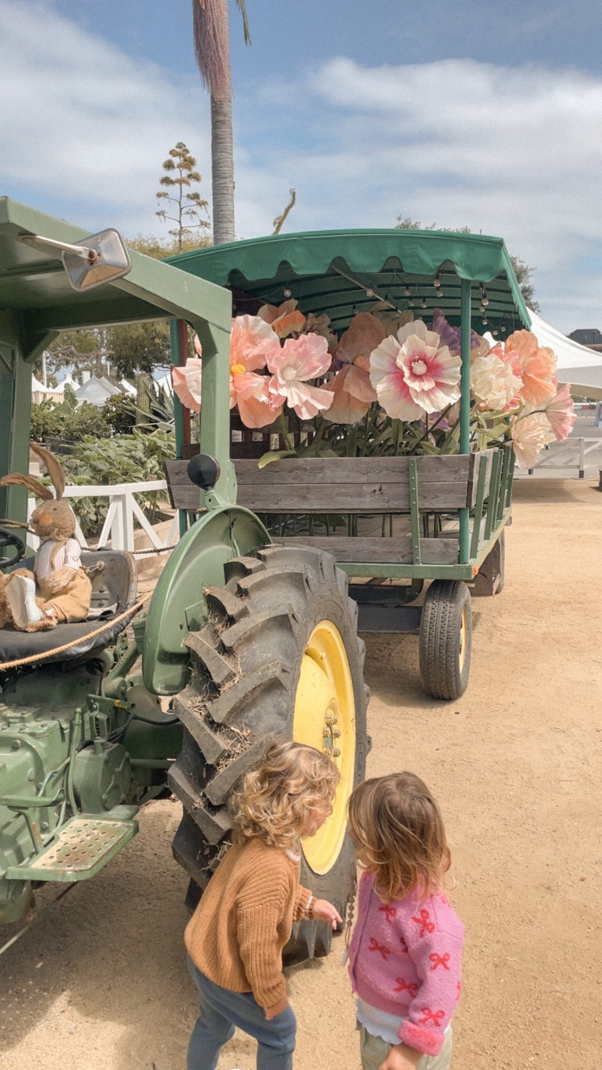 Two-year-old twins exploring beside a tractor at Centennial Farm in Costa Mesa